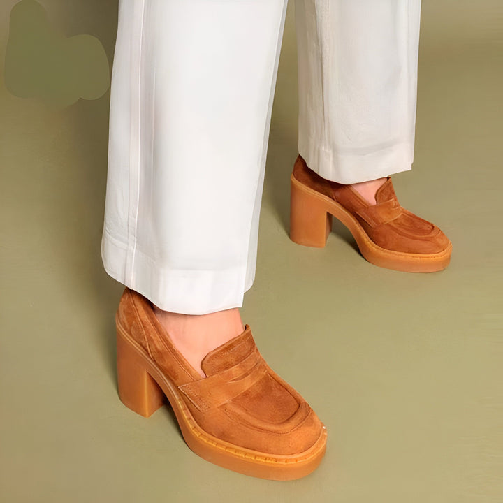 Gros plan sur des mocassins marron à talons épais, portés avec un pantalon blanc ample. Style décontracté et tendance., 45287055687861,45287055720629,45287055753397,45287055786165,45287055818933,45287055851701,45287055884469,45287055917237,45287055950005,45287055982773,45287056015541,45287056048309,45287056081077,45287056113845