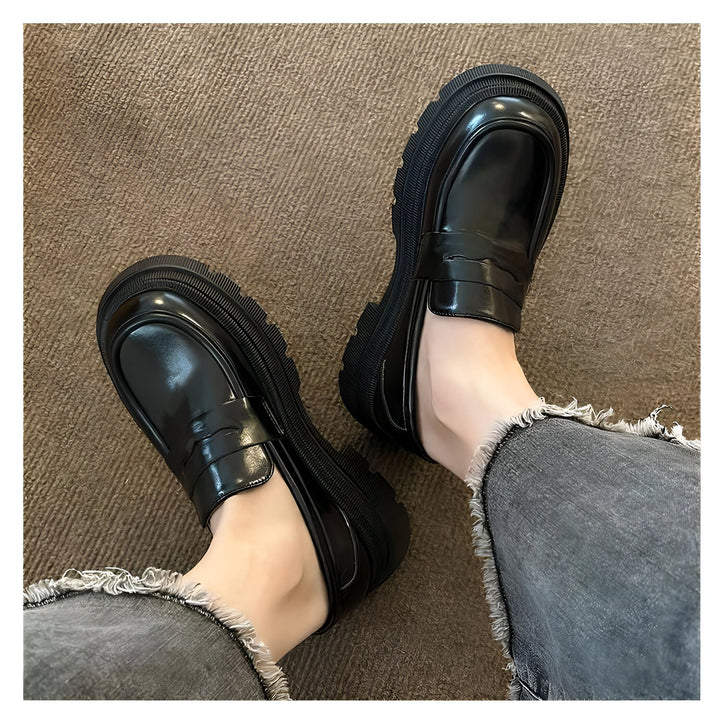 Vue plongeante de deux chaussures mocassins noires à semelles épaisses portées avec un jean délavé gris. Chaussures en cuir verni., 45286864093365,45286864126133,45286864158901,45286864191669,45286864224437,45286864257205,45286864289973,45286864322741,45286864355509,45286864388277