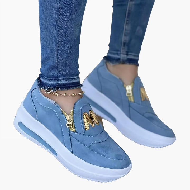Chaussures compensées bleu clair avec fermeture éclair dorée et lettrage "M" doré. Portées avec un jean bleu., 45286880313525,45286880346293,45286880379061,45286880411829,45286880444597,45286880477365,45286880510133,45286880542901,45286880575669,45286880608437,45286880641205,45286880673973,45286880706741,45286880739509,45286880772277,45286880805045,45286880837813,45286880870581,45286880903349,45286880936117,45286880968885,45286881001653,45286881034421,45286881067189,45286881099957,45286881132725,4528