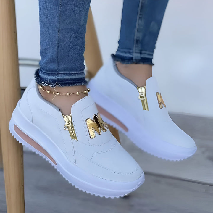 Gros plan de chaussures de sport blanches avec fermeture éclair décorative dorée. Style décontracté avec jean et chaîne de cheville dorée. Chaussures confortables et tendance., 45286880313525,45286880346293,45286880379061,45286880411829,45286880444597,45286880477365,45286880510133,45286880542901,45286880575669,45286880608437,45286880641205,45286880673973,45286880706741,45286880739509,45286880772277,45286880805045,45286880837813,45286880870581,45286880903349,45286880936117,45286880968885,45286881001