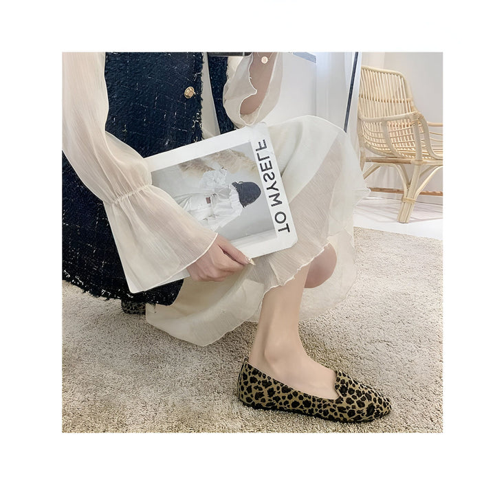 Une femme assise, portant une robe blanche et un veston noir, tient un magazine "TO MY REGRET" et porte des chaussures plates à imprimé léopard., 45287150485685,45287150518453,45287150551221,45287150583989,45287150616757,45287150649525,45287150682293,45287150715061,45287150747829