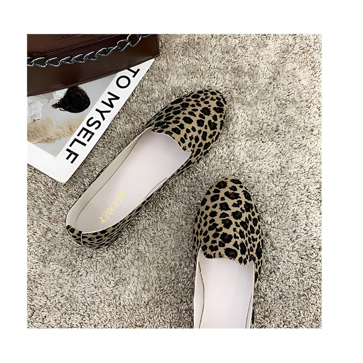 Vue de dessus de deux ballerines à motif léopard beige et noir, posées sur un tapis texturé beige clair. Un sac à main marron avec une chaîne et un magazine "TO MYSELF" sont partiellement visibles à côté., 45287150485685,45287150518453,45287150551221,45287150583989,45287150616757,45287150649525,45287150682293,45287150715061,45287150747829