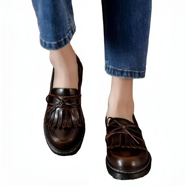 Gros plan de mocassins à franges en cuir marron portés avec un jean bleu, mettant en valeur le style décontracté et élégant des chaussures pour femmes. Chaussures tendance avec détails de nœud., 45286718308533,45286718341301,45286718374069,45286718406837,45286718439605,45286718472373,45286718505141,45286718537909,45286718570677,45286718603445,45286718636213,45286718668981,45286718701749,45286718734517