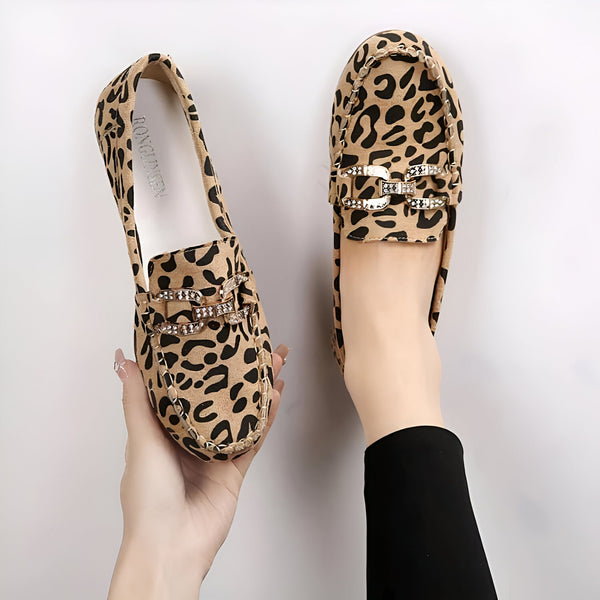 Mocassins léopard élégants avec détail de boucle ornée. Une paire est tenue à la main, l'autre est portée. Chaussures tendance pour femme, style animalier., 45287153434805,45287153467573,45287153500341,45287153533109,45287153565877,45287153598645,45287153631413,45287153664181,45287153696949,45287153729717,45287153762485,45287153795253,45287153828021,45287153860789