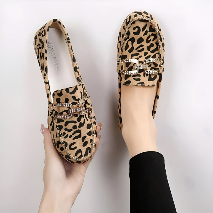 Mocassins léopard élégants avec détail de boucle ornée. Une paire est tenue à la main, l'autre est portée. Chaussures tendance pour femme, style animalier., 45287153434805,45287153467573,45287153500341,45287153533109,45287153565877,45287153598645,45287153631413,45287153664181,45287153696949,45287153729717,45287153762485,45287153795253,45287153828021,45287153860789
