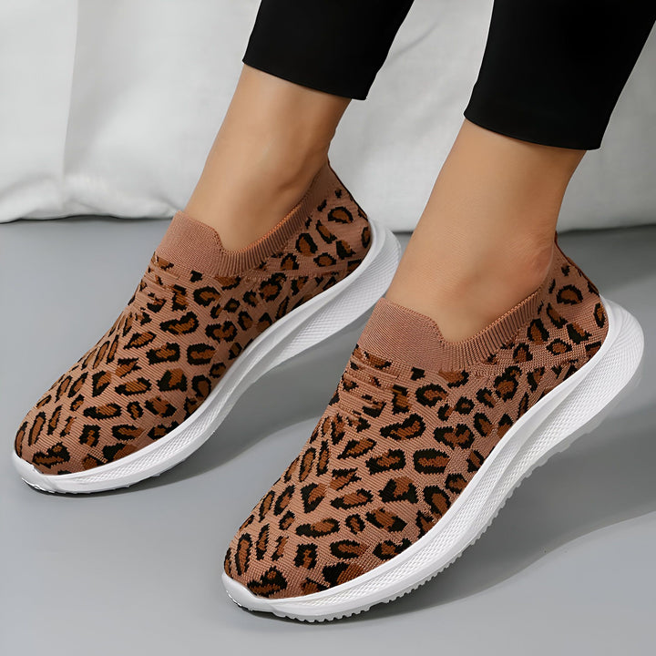 Chaussures slip-on léopard marron avec semelles blanches. Vue rapprochée des pieds portant des baskets à motif animal. Style décontracté, confort et mode. Tendance chaussures pour femme., 45287151501493,45287151534261,45287151567029,45287151599797,45287151632565,45287151665333,45287151698101,45287151730869