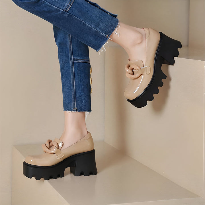 Gros plan sur des chaussures à plateforme vernies beiges avec talon noir épais, portées avec un jean bleu clair. Détail de la boucle décorative sur le dessus des chaussures. Style tendance et audacieux., 45286886965429,45286886998197,45286887030965,45286887063733,45286887096501,45286887129269,45286887162037,45286887194805,45286887227573,45286887260341,45286887293109,45286887325877
