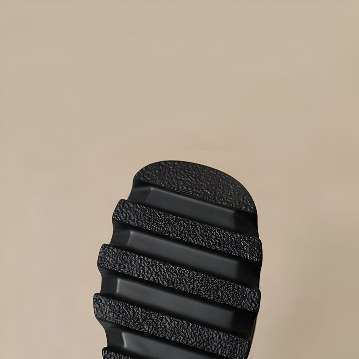 Gros plan de la semelle noire d'une chaussure, montrant les rainures antidérapantes. Texture détaillée, fond beige uni. Semelle robuste pour une bonne adhérence., 45286886965429,45286886998197,45286887030965,45286887063733,45286887096501,45286887129269,45286887162037,45286887194805,45286887227573,45286887260341,45286887293109,45286887325877