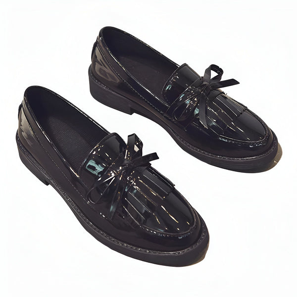 Une paire de mocassins noirs vernis avec des franges et un nœud décoratif. Chaussures élégantes et brillantes pour femme. Mode et style., 45287001292981,45287001325749,45287001358517,45287001391285,45287001424053,45287001456821,45287001489589,45287001522357,45287001555125,45287001587893
