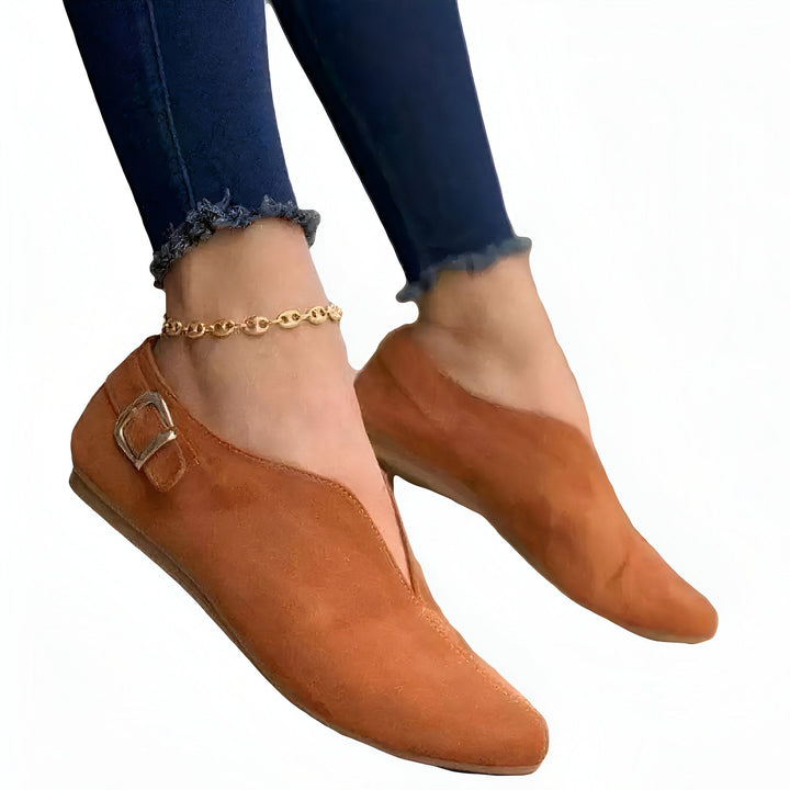 Gros plan de pieds portant des ballerines pointues en daim marron avec une boucle et un jean bleu. Une chaîne de cheville dorée ajoute une touche d'élégance. Chaussures confortables et élégantes., 45287113621685,45287113654453,45287113687221,45287113719989,45287113752757,45287113785525,45287113818293,45287113851061,45287113883829,45287113916597,45287113949365,45287113982133,45287114014901,45287114047669,45287114080437,45287114113205,45287114145973,45287114178741,45287114211509,45287114244277,4528711