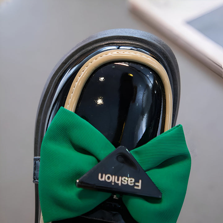 Gros plan d'une chaussure vernie noire pour enfant avec un nœud vert vif et l'inscription "Fashion". Chaussure élégante pour petite fille., 45287024033973,45287024066741,45287024099509,45287024132277,45287024165045,45287024197813,45287024230581,45287024263349,45287024296117,45287024328885,45287024361653,45287024394421,45287024427189,45287024459957,45287024492725,45287024525493,45287024558261,45287024591029,45287024623797,45287024656565,45287024689333,45287024722101,45287024754869,45287024787637,4528702