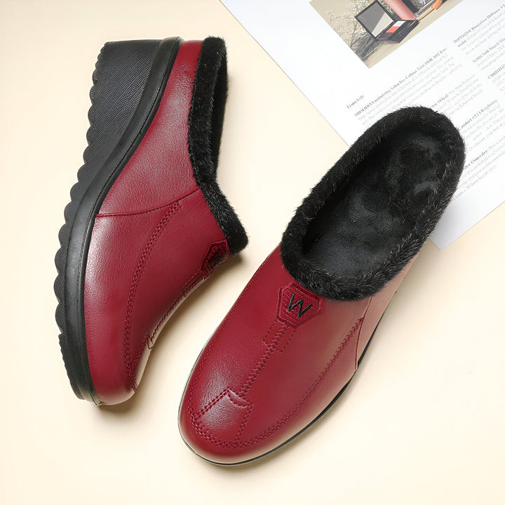 Vue rapprochée d'une paire de chaussons mules bordeaux pour femmes, doublés de fourrure noire. Chaussures confortables à semelle compensée, idéales pour l'hiver. Détail du logo "W" sur le dessus., 45286906331317,45286906364085,45286906396853,45286906429621,45286906462389,45286906495157,45286906527925,45286906560693,45286906593461,45286906626229,45286906658997,45286906691765,45286906724533,45286906757301