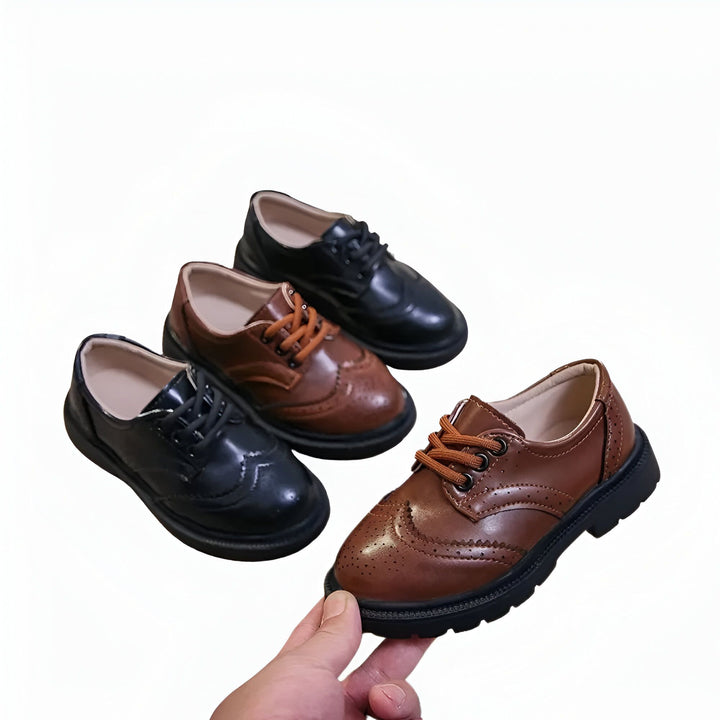 Chaussures de ville pour enfants en cuir marron et noir. Mocassins élégants pour garçon. Détail d'une main tenant une chaussure, présentées sur un fond blanc., 45286680232117,45286680264885,45286680297653,45286680330421,45286680363189,45286680395957,45286680428725,45286680461493,45286680494261,45286680527029,45286680559797,45286680592565,45286680625333,45286680658101,45286680690869,45286680723637,45286680756405,45286680789173,45286680821941,45286680854709,45286680887477,45286680920245