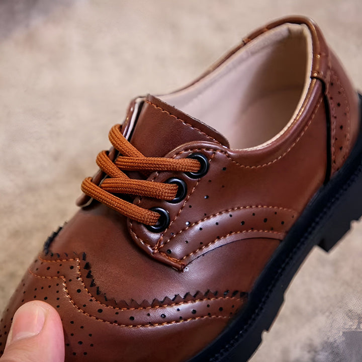 Gros plan d'une chaussure habillée marron pour enfants, avec lacets marron, détails perforés et semelle noire épaisse. Style élégant et confortable., 45286680232117,45286680264885,45286680297653,45286680330421,45286680363189,45286680395957,45286680428725,45286680461493,45286680494261,45286680527029,45286680559797,45286680592565,45286680625333,45286680658101,45286680690869,45286680723637,45286680756405,45286680789173,45286680821941,45286680854709,45286680887477,45286680920245