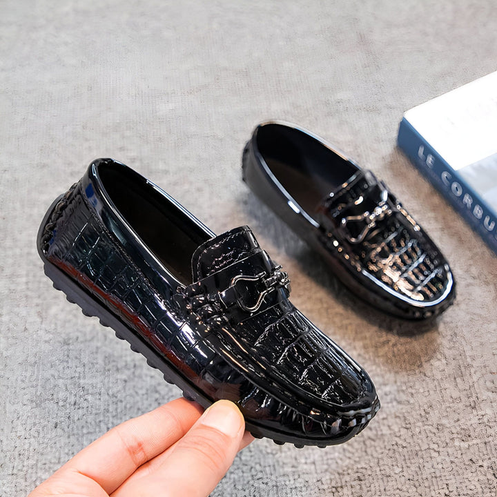Mocassins noirs vernis à motif crocodile, chaussures élégantes pour enfant, détail raffiné avec boucle métallique, présentés avec un livre en arrière-plan., 45286767296693,45286767329461,45286767362229,45286767394997,45286767427765,45286767460533,45286767493301,45286767526069,45286767558837,45286767591605,45286767624373,45286767657141,45286767689909,45286767722677,45286767755445,45286767788213,45286767820981,45286767853749,45286767886517,45286767919285,45286767952053,45286767984821,45286768017589