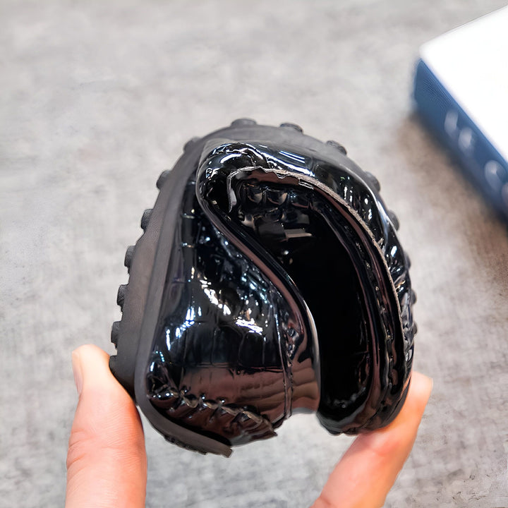 Gros plan d'une chaussure noire vernie pliée, montrant sa flexibilité et sa texture en relief. Idéale pour illustrer le confort et la qualité des chaussures., 45286767296693,45286767329461,45286767362229,45286767394997,45286767427765,45286767460533,45286767493301,45286767526069,45286767558837,45286767591605,45286767624373,45286767657141,45286767689909,45286767722677,45286767755445,45286767788213,45286767820981,45286767853749,45286767886517,45286767919285,45286767952053,45286767984821,45286768017589,45