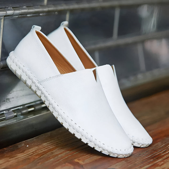 Paire de mocassins blancs en cuir sur une surface en bois, design minimaliste, semelle souple, style décontracté et élégant, confort et légèreté, chaussures tendance pour hommes et femmes., 45286787743925,45286787776693,45286787809461,45286787842229,45286787874997,45286787907765,45286787940533