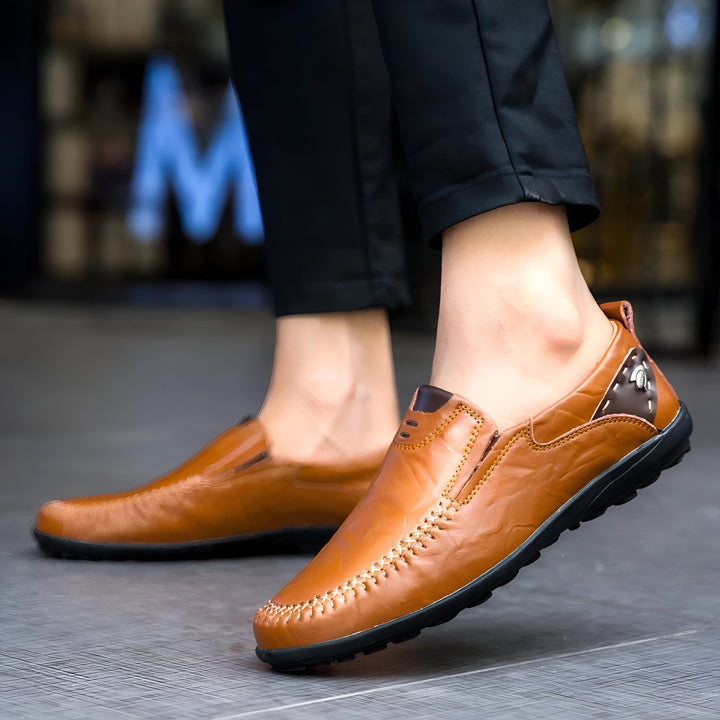 Homme portant des mocassins en cuir marron avec un pantalon noir. Détail des coutures apparentes. Chaussures élégantes et confortables pour un style décontracté chic., 45286896206005,45286896238773,45286896271541,45286896304309,45286896337077,45286896369845,45286896402613,45286896435381,45286896468149,45286896500917,45286896533685,45286896566453,45286896599221,45286896631989,45286896664757,45286896697525,45286896730293,45286896763061,45286896795829,45286896828597,45286896861365,45286896894133,4528689