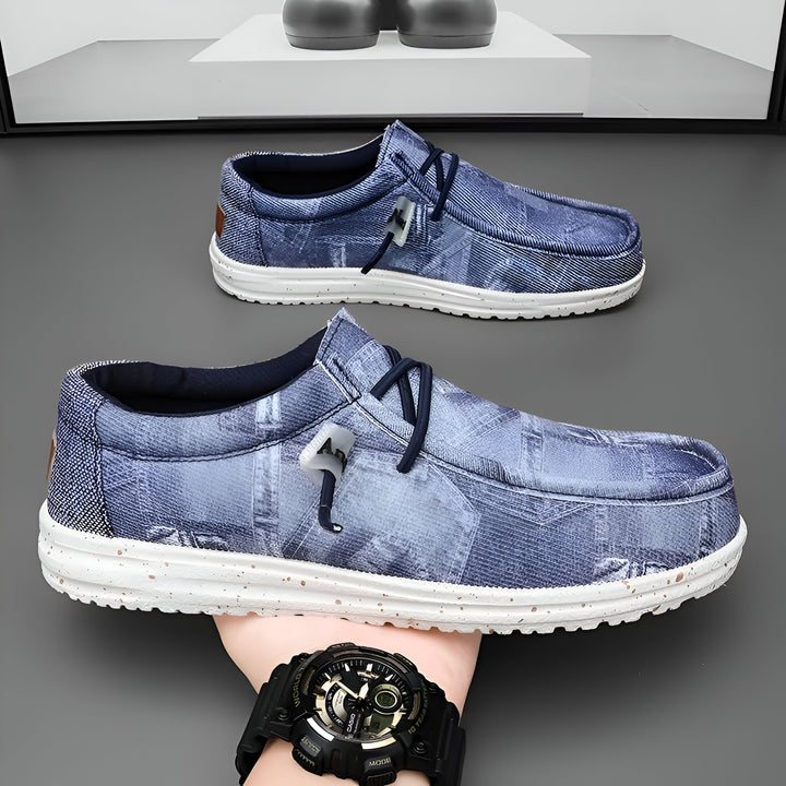 Chaussures décontractées en denim bleu et semelle blanche mouchetée. Une main tient une chaussure, montrant une montre noire. Autres chaussures identiques en arrière-plan., 45286670532789,45286670565557,45286670598325,45286670631093,45286670663861,45286670696629,45286670729397,45286670762165,45286670794933,45286670827701,45286670860469,45286670893237,45286670926005,45286670958773,45286670991541,45286671024309,45286671057077,45286671089845,45286671122613,45286671155381,45286671188149,45286671220917,452