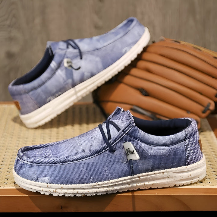 Chaussures décontractées bleues en tissu avec lacets et semelle blanche, posées sur une table en bois. Un gant de baseball en cuir est visible en arrière-plan., 45286670532789,45286670565557,45286670598325,45286670631093,45286670663861,45286670696629,45286670729397,45286670762165,45286670794933,45286670827701,45286670860469,45286670893237,45286670926005,45286670958773,45286670991541,45286671024309,45286671057077,45286671089845,45286671122613,45286671155381,45286671188149,45286671220917,45286671253685,
