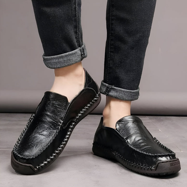 Gros plan sur des mocassins en cuir noir portés avec un jean foncé. Chaussures décontractées pour homme. Détails de couture visibles. Mode masculine et confort., 45286710182069,45286710214837,45286710247605,45286710280373,45286710313141,45286710345909,45286710378677,45286710411445,45286710444213,45286710476981,45286710509749,45286710542517,45286710575285,45286710608053,45286710640821,45286710673589,45286710706357,45286710739125,45286710771893,45286710837429,45286710870197,45286710902965,4528671093573