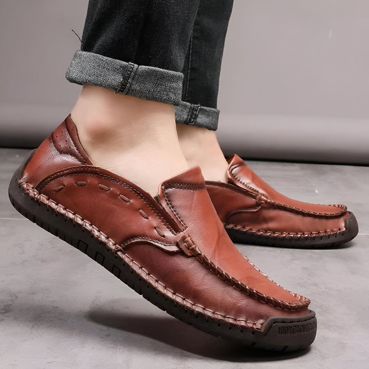 Mocassins en cuir marron portés avec un jean noir. Chaussures confortables, décontractées et élégantes pour hommes. Détails de couture artisanale. Style slip-on facile à porter., 45286710182069,45286710214837,45286710247605,45286710280373,45286710313141,45286710345909,45286710378677,45286710411445,45286710444213,45286710476981,45286710509749,45286710542517,45286710575285,45286710608053,45286710640821,45286710673589,45286710706357,45286710739125,45286710771893,45286710837429,45286710870197,452867109