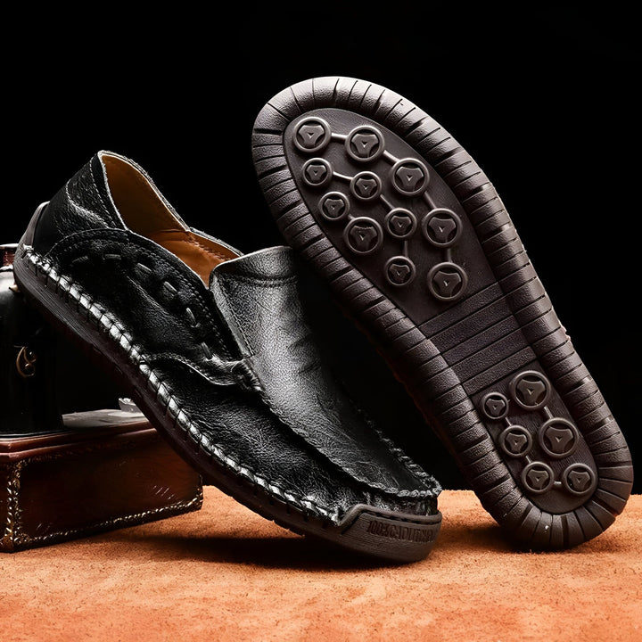 Mocassins noirs en cuir pour hommes, vus de près. Une chaussure est posée, l'autre montre sa semelle texturée. Couture claire et design élégant., 45286710182069,45286710214837,45286710247605,45286710280373,45286710313141,45286710345909,45286710378677,45286710411445,45286710444213,45286710476981,45286710509749,45286710542517,45286710575285,45286710608053,45286710640821,45286710673589,45286710706357,45286710739125,45286710771893,45286710837429,45286710870197,45286710902965,45286710935733,45286710968501