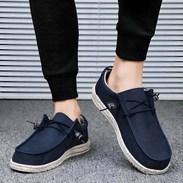 Homme portant des mocassins bleu marine décontractés avec lacets et semelles texturées, assortis à un pantalon de jogging noir. Style confortable et moderne., 45286677643445,45286677676213,45286677708981,45286677741749,45286677774517,45286677807285,45286677840053,45286677872821,45286677905589,45286677938357,45286677971125,45286678003893,45286678036661,45286678069429,45286678102197,45286678134965,45286678167733,45286678200501