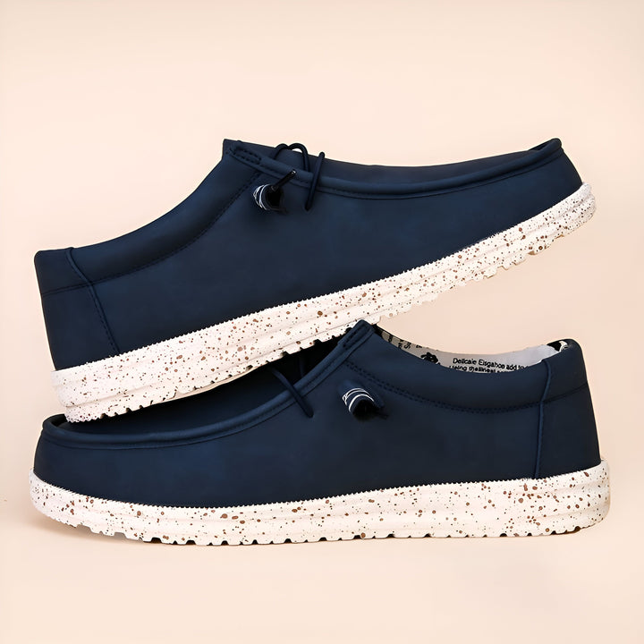 Deux chaussures décontractées bleu marine, empilées l'une sur l'autre. Elles ont des semelles blanches avec des mouchetures brunes et des lacets noirs., 45286677643445,45286677676213,45286677708981,45286677741749,45286677774517,45286677807285,45286677840053,45286677872821,45286677905589,45286677938357,45286677971125,45286678003893,45286678036661,45286678069429,45286678102197,45286678134965,45286678167733,45286678200501