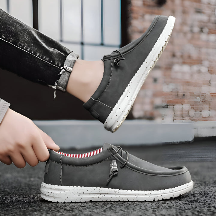 Chaussures décontractées grises pour hommes avec semelle blanche mouchetée, portées avec un jean noir. Style mocassin avec lacets décoratifs. Mode masculine, confort et décontraction., 45286686621877,45286686654645,45286686687413,45286686720181,45286686752949,45286686785717,45286686818485,45286686851253,45286686884021,45286686916789,45286686949557,45286686982325,45286687015093,45286687047861,45286687080629,45286687113397,45286687146165,45286687178933,45286687211701,45286687244469,45286687277237