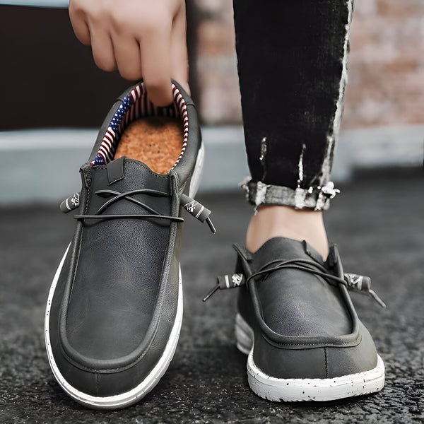 Gros plan de chaussures décontractées grises en cuir pour homme avec des lacets et une doublure intérieure à rayures rouges, blanches et bleues, sur une personne portant un jean noir., 45286686621877,45286686654645,45286686687413,45286686720181,45286686752949,45286686785717,45286686818485,45286686851253,45286686884021,45286686916789,45286686949557,45286686982325,45286687015093,45286687047861,45286687080629,45286687113397,45286687146165,45286687178933,45286687211701,45286687244469,45286687277237