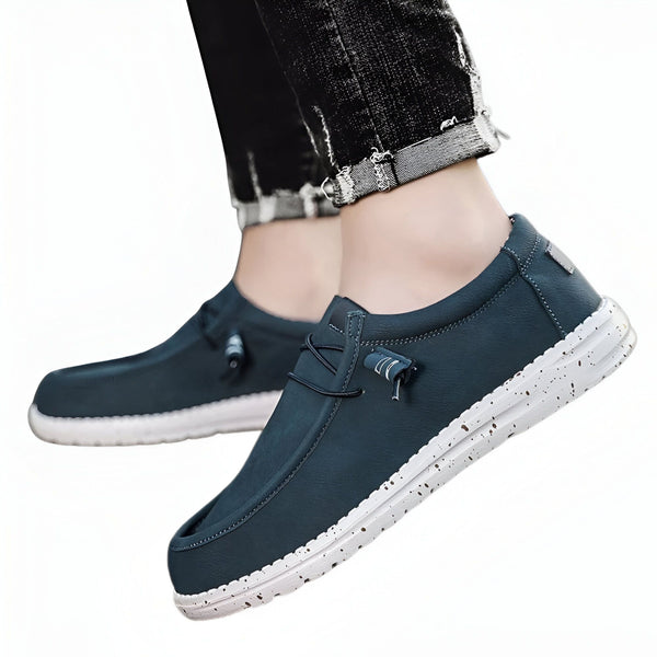 Gros plan d'une paire de chaussures décontractées bleu pétrole avec des lacets élastiques et une semelle blanche mouchetée, portées avec un jean noir retroussé., 45286686621877,45286686654645,45286686687413,45286686720181,45286686752949,45286686785717,45286686818485,45286686851253,45286686884021,45286686916789,45286686949557,45286686982325,45286687015093,45286687047861,45286687080629,45286687113397,45286687146165,45286687178933,45286687211701,45286687244469,45286687277237