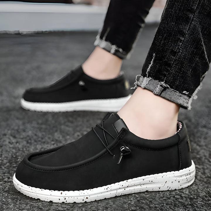 Gros plan de chaussures décontractées noires avec semelles blanches mouchetées, portées avec un jean noir effiloché. Mode masculine, chaussures confortables et élégantes., 45286686621877,45286686654645,45286686687413,45286686720181,45286686752949,45286686785717,45286686818485,45286686851253,45286686884021,45286686916789,45286686949557,45286686982325,45286687015093,45286687047861,45286687080629,45286687113397,45286687146165,45286687178933,45286687211701,45286687244469,45286687277237