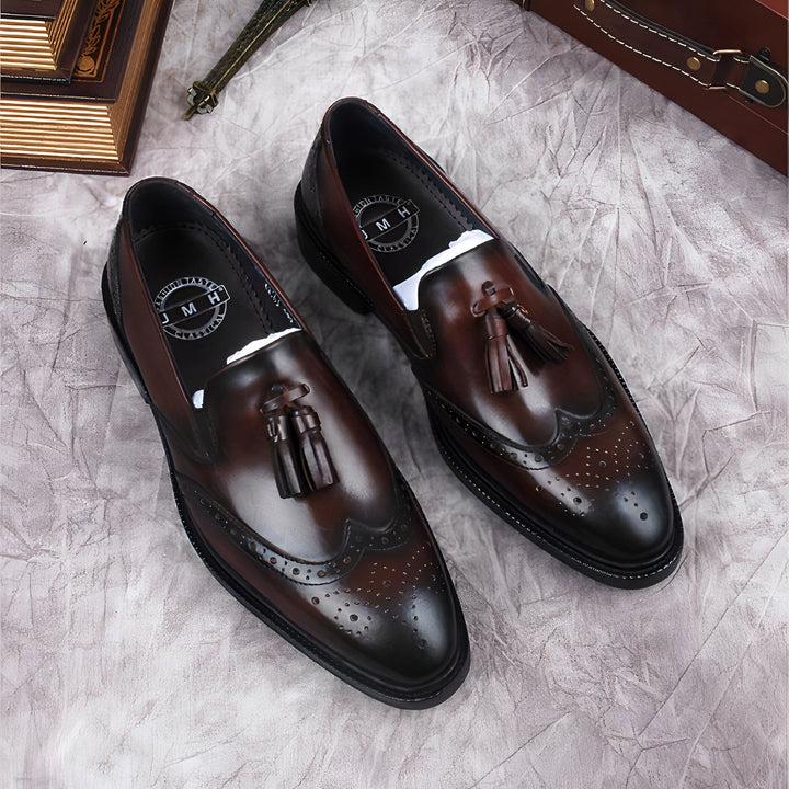 Une paire de mocassins en cuir marron à glands pour homme sur fond texturé gris. Chaussures élégantes et sophistiquées. Détails perforés et finitions impeccables. Accessoires de mode masculine., 45286843941045,45286843973813,45286844006581,45286844039349,45286844072117,45286844104885,45286844137653