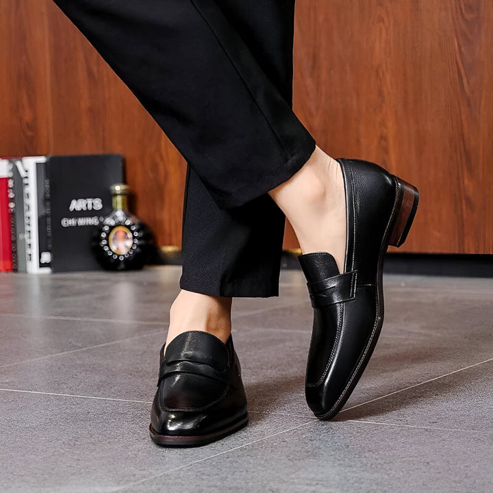 Gros plan sur des mocassins noirs en cuir portés avec un pantalon noir. Chaussures élégantes pour homme avec talon en bois, parfaites pour un look formel ou décontracté chic., 45286724042933,45286724075701,45286724108469,45286724141237,45286724174005,45286724206773,45286724239541,45286724272309,45286724305077,45286724337845,45286724370613,45286724403381,45286724436149,45286724468917