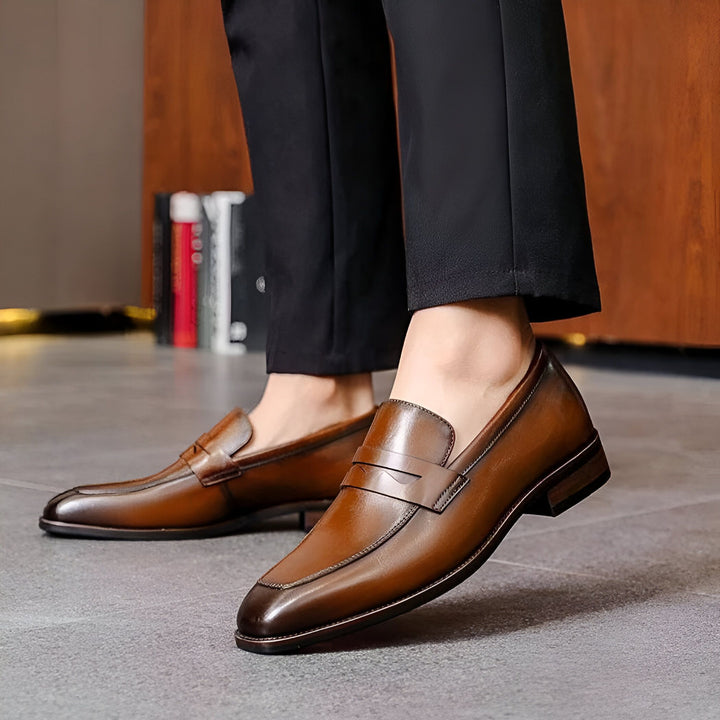 Gros plan sur une personne portant des mocassins en cuir marron élégants avec un pantalon noir. Chaussures de ville, mode masculine., 45286724042933,45286724075701,45286724108469,45286724141237,45286724174005,45286724206773,45286724239541,45286724272309,45286724305077,45286724337845,45286724370613,45286724403381,45286724436149,45286724468917