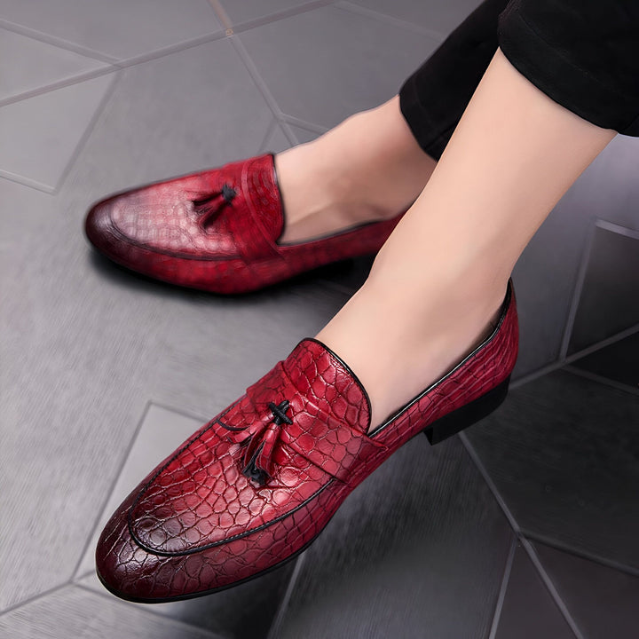 Chaussures mocassins rouges en cuir avec motif peau de serpent, dotées de glands décoratifs, portées par une personne assise. Idéal pour un look élégant et original. Mode masculine., 45287059423413,45287059456181,45287059488949,45287059521717,45287059554485,45287059587253,45287059620021,45287059652789,45287059685557,45287059718325,45287059751093,45287059783861,45287059816629,45287059849397,45287059882165,45287059914933,45287059947701,45287059980469,45287060013237,45287060046005,45287060078773,452870