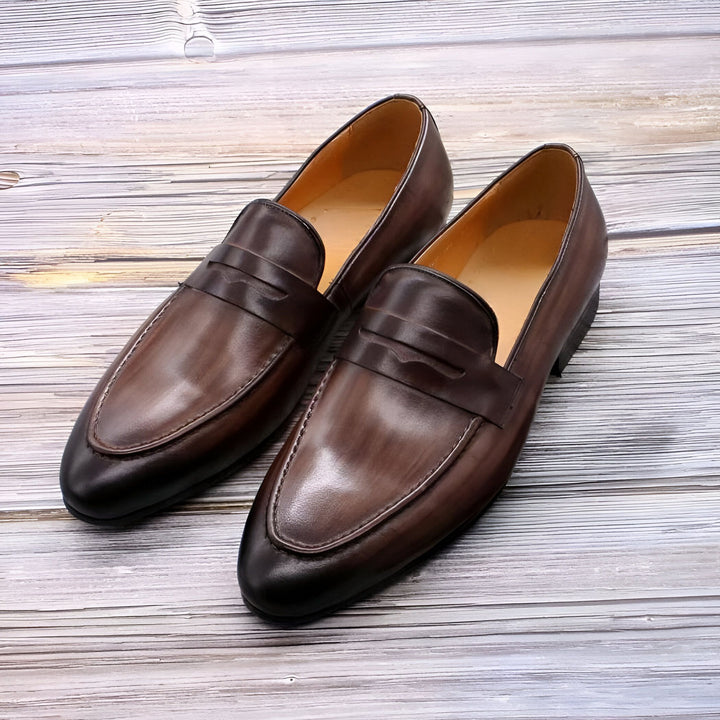 Paire de mocassins classiques en cuir marron sur fond de bois. Chaussures élégantes pour hommes, idéales pour une tenue formelle ou décontractée. Détails soignés et finitions raffinées., 45286715850933,45286715883701,45286715916469,45286715949237,45286715982005,45286716014773,45286716047541,45286716080309,45286716113077,45286716145845