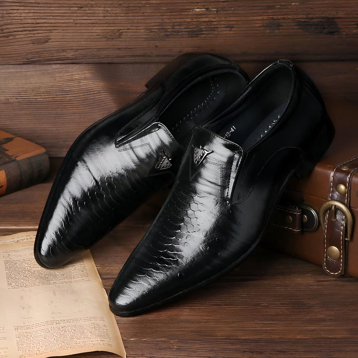 Deux chaussures habillées noires en cuir lisse et texturé, avec un petit ornement métallique, présentées sur une surface en bois avec une valise vintage et un document ancien. Idéal pour la mode masculine et le style classique., 45287064010933,45287064043701,45287064076469,45287064109237,45287064142005,45287064174773,45287064207541,45287064240309,45287064273077,45287064305845,45287064338613,45287064371381,45287064404149,45287064436917,45287064469685,45287064502453,45287064535221,45287064567989,45287
