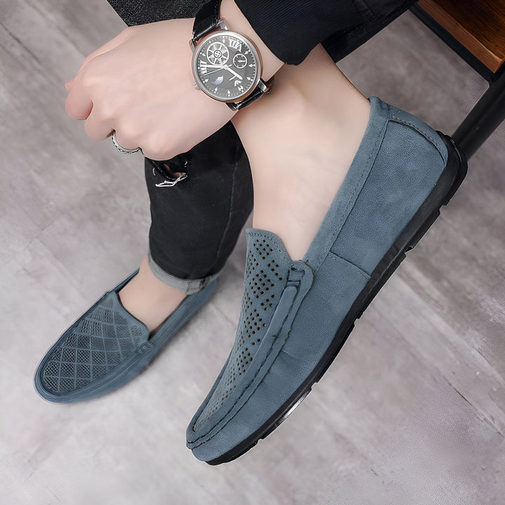 Gros plan sur des mocassins en daim bleu portés par un homme avec une montre élégante. Chaussures décontractées et confortables, parfaites pour un look moderne et détendu. Détails perforés et texture en daim mise en valeur., 45286807732405,45286807765173,45286807797941,45286807830709,45286807863477,45286807896245,45286807929013,45286807961781,45286807994549,45286808027317,45286808060085,45286808092853