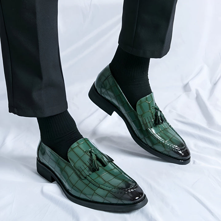 Gros plan sur des mocassins verts en peau de crocodile portés avec un pantalon noir et des chaussettes noires. Chaussures élégantes avec détails à glands., 45286642286773,45286642319541,45286642352309,45286642385077,45286642417845,45286642450613,45286642483381,45286642516149,45286642548917,45286642581685,45286642614453,45286642647221,45286642679989,45286642712757,45286642745525,45286642778293,45286642811061,45286642843829,45286642876597,45286642909365,45286642942133,45286642974901,45286643007669,4528