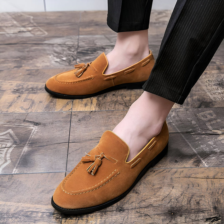 Gros plan sur des mocassins marron en daim avec des glands, portés avec un pantalon habillé à rayures fines, sur un sol en bois. Mode masculine élégante et décontractée., 45287110410421,45287110443189,45287110475957,45287110508725,45287110541493,45287110574261,45287110607029,45287110639797,45287110672565,45287110705333,45287110738101