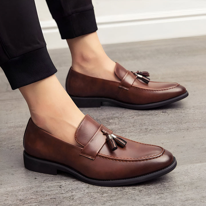 Gros plan de mocassins marron en cuir avec des glands portés par un homme avec un pantalon noir., 45286937690293,45286937723061,45286937755829,45286937788597,45286937821365,45286937854133,45286937886901,45286937919669,45286937952437,45286937985205,45286938017973,45286938050741,45286938083509,45286938116277,45286938149045,45286938181813,45286938214581,45286938247349