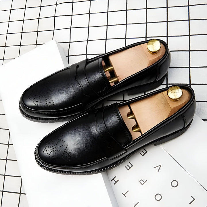 Deux mocassins noirs en cuir avec embauchoirs en bois posés sur un livre blanc et un tissu à carreaux. Chaussures élégantes pour hommes avec perforations décoratives., 45286714966197,45286714998965,45286715031733,45286715064501,45286715097269,45286715130037,45286715162805,45286715195573,45286715228341,45286715261109,45286715293877,45286715326645,45286715359413,45286715392181,45286715424949,45286715457717,45286715490485,45286715523253