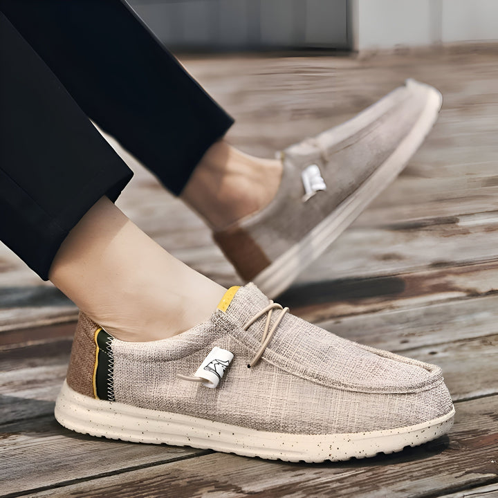 Homme portant des chaussures décontractées beiges en lin, pantalon noir, posé sur une terrasse en bois. Chaussures confortables pour l'été, style mocassin., 45286690422965,45286690455733,45286690488501,45286690521269,45286690554037,45286690586805,45286690619573,45286690652341,45286690685109,45286690717877,45286690750645,45286690783413,45286690816181,45286690848949,45286690881717,45286690914485,45286690947253,45286690980021,45286691012789,45286691045557,45286691078325,45286691111093,45286691143861,452