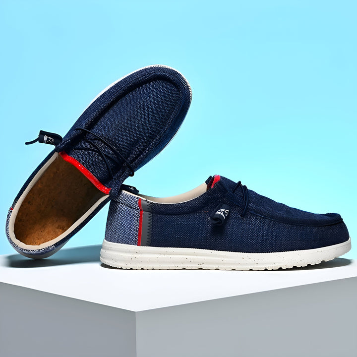 Chaussures décontractées bleues en toile, style mocassin, avec lacets élastiques. Semelle blanche et détails rouges à l'intérieur. Une chaussure est posée sur le côté, montrant la semelle intérieure en liège. Confort et style décontracté., 45286690422965,45286690455733,45286690488501,45286690521269,45286690554037,45286690586805,45286690619573,45286690652341,45286690685109,45286690717877,45286690750645,45286690783413,45286690816181,45286690848949,45286690881717,45286690914485,45286690947253,45