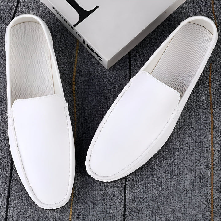 Deux mocassins blancs en cuir, vus du dessus, posés sur un tapis gris texturé. Un livre blanc est partiellement visible à l'arrière-plan. Chaussures élégantes, mode masculine, look décontracté., 45287127154869,45287127187637,45287127220405,45287127253173,45287127285941,45287127318709,45287127351477,45287127384245,45287127417013,45287127449781,45287127482549,45287127515317,45287127548085,45287127580853,45287127613621,45287127646389,45287127679157,45287127711925,45287127744693,45287127777461