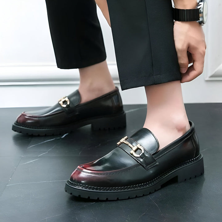 Gros plan sur des mocassins en cuir noir verni avec détail de mors doré portés par un homme élégant en pantalon noir. Montre visible au poignet. Chaussures de ville chics et tendance., 45286714114229,45286714146997,45286714179765,45286714212533,45286714245301,45286714278069,45286714310837,45286714343605,45286714376373,45286714409141,45286714441909,45286714474677,45286714507445,45286714540213