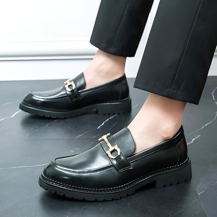 Gros plan sur des mocassins en cuir noir pour hommes, avec une boucle dorée décorative, portés avec un pantalon noir élégant. Chaussures de ville luxueuses et modernes., 45286714114229,45286714146997,45286714179765,45286714212533,45286714245301,45286714278069,45286714310837,45286714343605,45286714376373,45286714409141,45286714441909,45286714474677,45286714507445,45286714540213