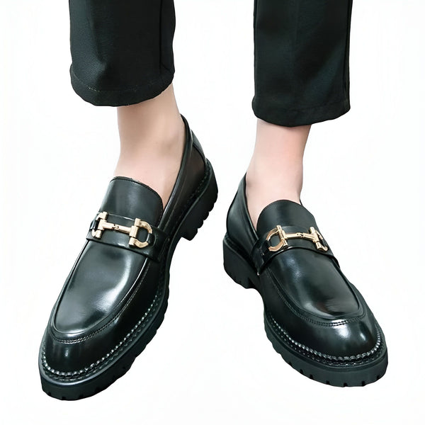 Gros plan sur des mocassins noirs en cuir portés par un homme. Ces chaussures élégantes sont dotées d'une bride dorée distinctive. Parfaites pour un look sophistiqué et tendance., 45286714114229,45286714146997,45286714179765,45286714212533,45286714245301,45286714278069,45286714310837,45286714343605,45286714376373,45286714409141,45286714441909,45286714474677,45286714507445,45286714540213